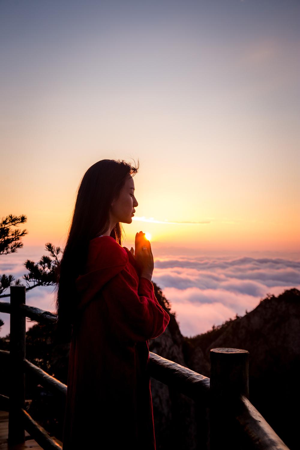 照片中,母其弥雅在山顶感受自然,搭配长裙文艺且不失仙气,在朝霞的